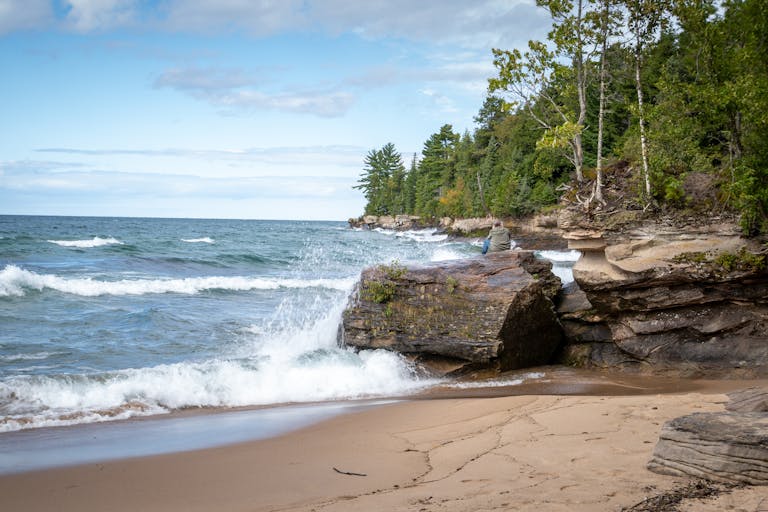 Dramatic waves crash against the rocky coastline of Lake Superior, capturing Michigan's natural beauty.