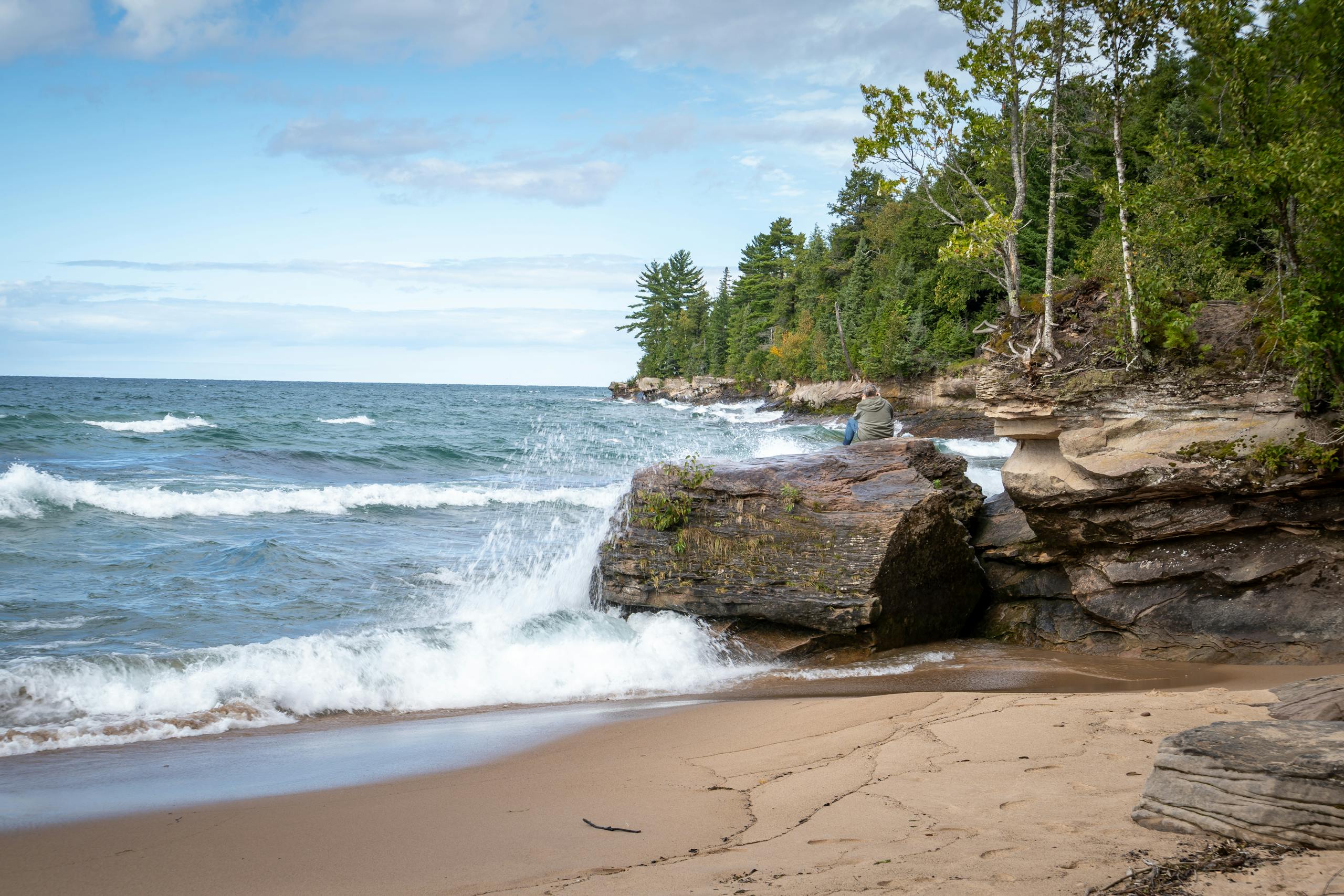 Dramatic waves crash against the rocky coastline of Lake Superior, capturing Michigan's natural beauty.
